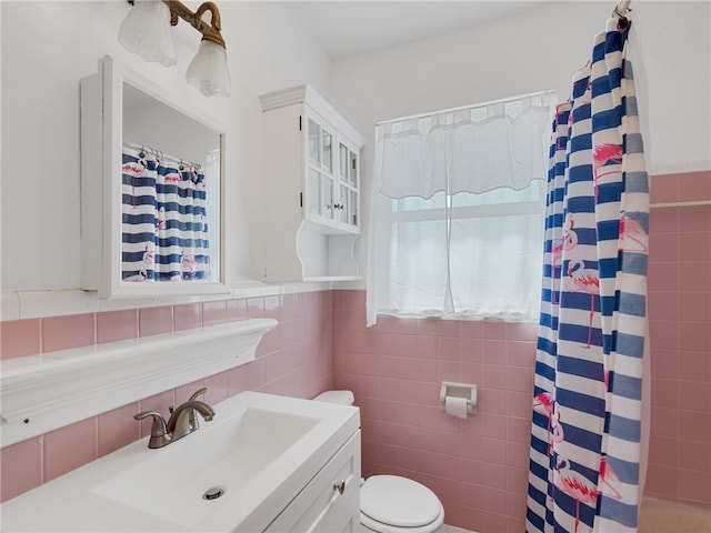 bathroom with tile walls, sink, toilet, and a shower with shower curtain