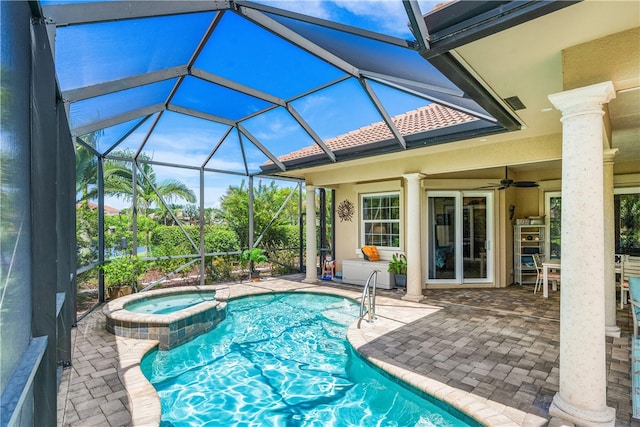 view of swimming pool featuring ceiling fan, a patio, glass enclosure, and an in ground hot tub