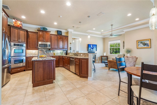 kitchen featuring kitchen peninsula, hanging light fixtures, ornamental molding, and stainless steel appliances