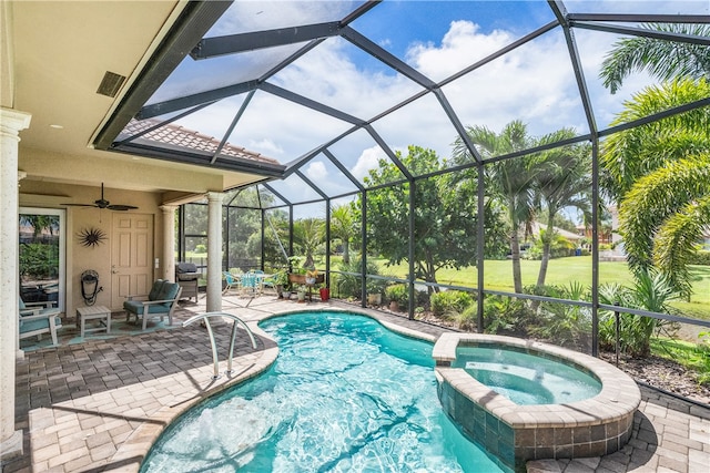 view of swimming pool with glass enclosure, an in ground hot tub, ceiling fan, and a patio