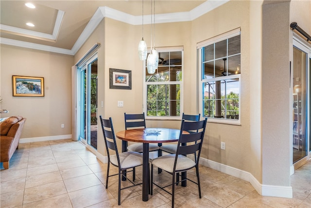 dining room featuring light tile patterned floors, a tray ceiling, and ornamental molding