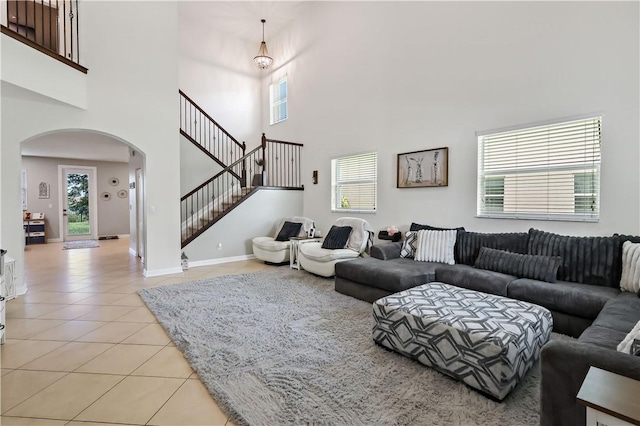 1782 Berkshire Cir SW, Vero Beach, FL 32968 - living room featuring arched walkways, light tile patterned floors, a towering ceiling, healthy amount of natural light, and stairway