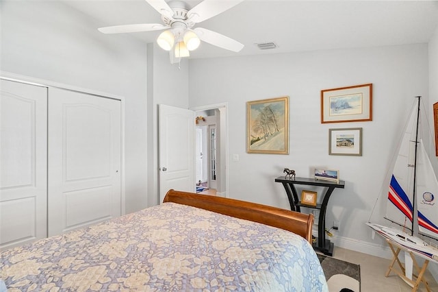 bedroom with ceiling fan, light tile patterned flooring, a closet, and lofted ceiling