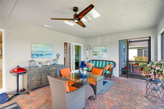 dining room featuring ceiling fan and a textured ceiling