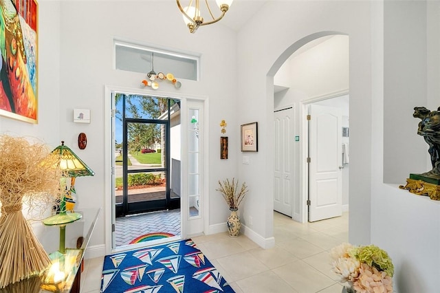 tiled foyer featuring a notable chandelier