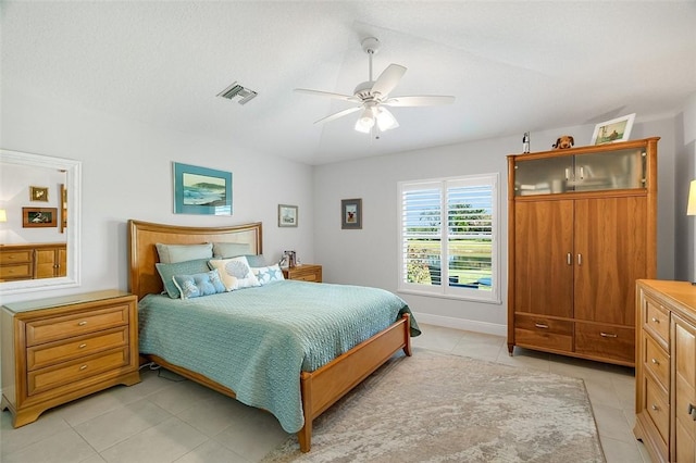 bedroom with ceiling fan and light tile patterned floors