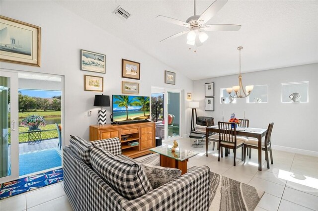 tiled living room featuring lofted ceiling, a textured ceiling, and ceiling fan with notable chandelier