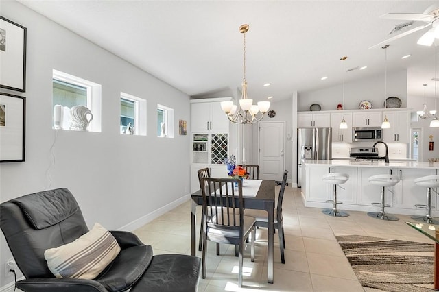 dining room featuring lofted ceiling, light tile patterned flooring, ceiling fan with notable chandelier, and sink