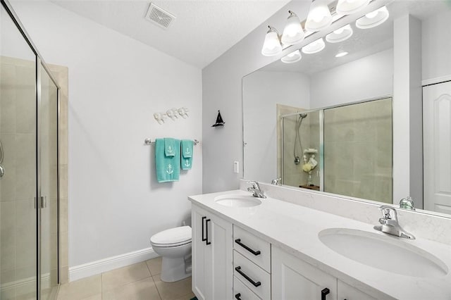 bathroom with toilet, tile patterned flooring, a shower with door, and vanity