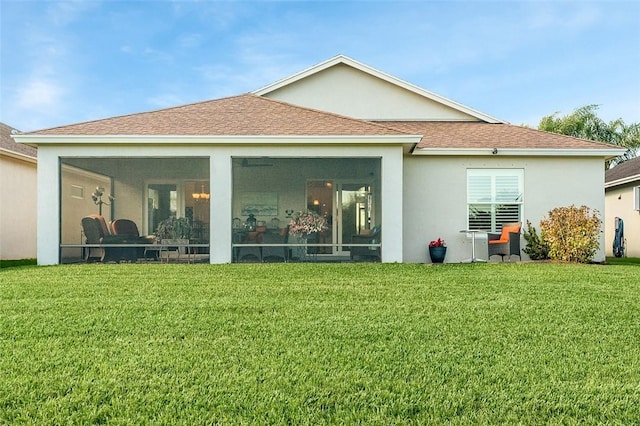 back of property featuring a yard and a sunroom