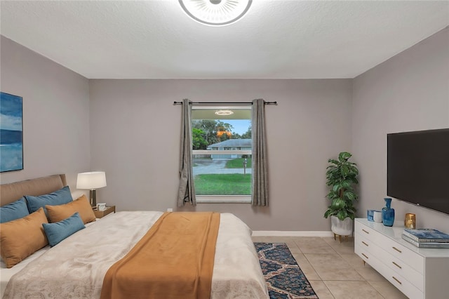 bedroom with a textured ceiling and light tile patterned flooring