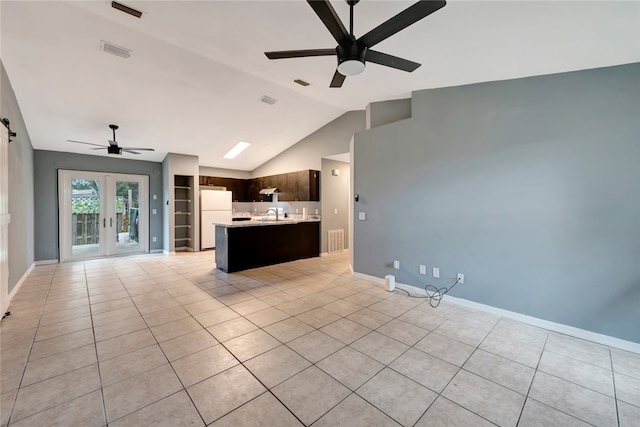 unfurnished living room featuring built in shelves, high vaulted ceiling, light tile patterned floors, and french doors