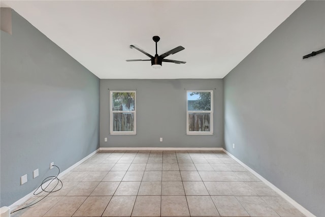 tiled spare room with ceiling fan