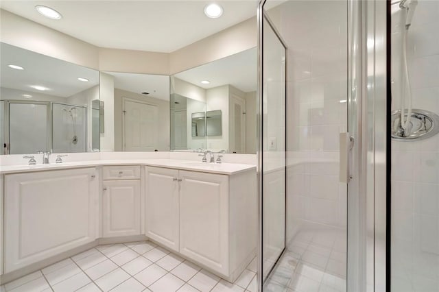 bathroom with a shower stall, tile patterned flooring, double vanity, and recessed lighting