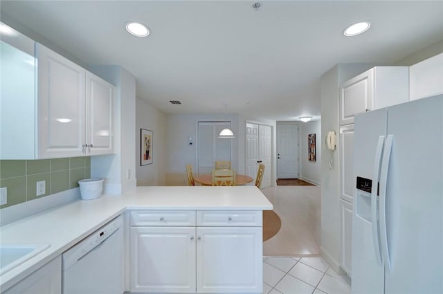kitchen featuring white appliances, white cabinets, a peninsula, and recessed lighting