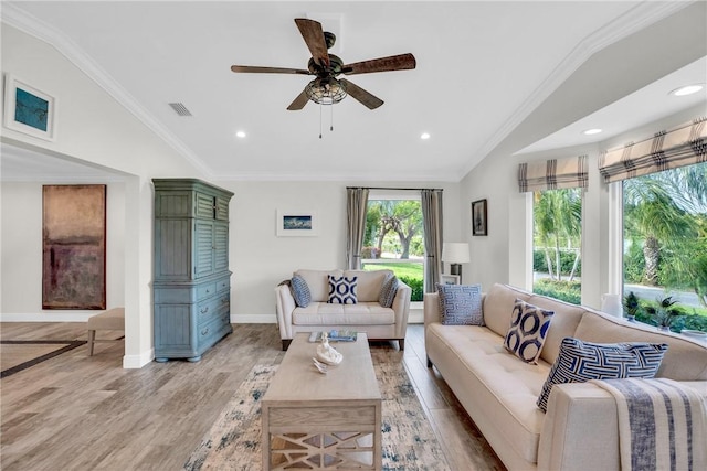 living room with lofted ceiling, visible vents, light wood-style flooring, ornamental molding, and baseboards