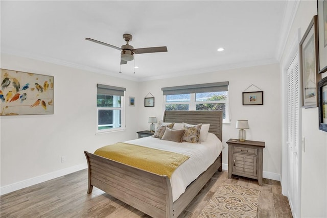 bedroom with light wood-style flooring, multiple windows, and crown molding