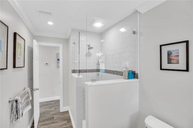 full bath featuring visible vents, toilet, wood finished floors, baseboards, and walk in shower