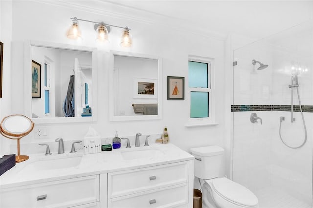 bathroom with a sink, a shower stall, toilet, and double vanity