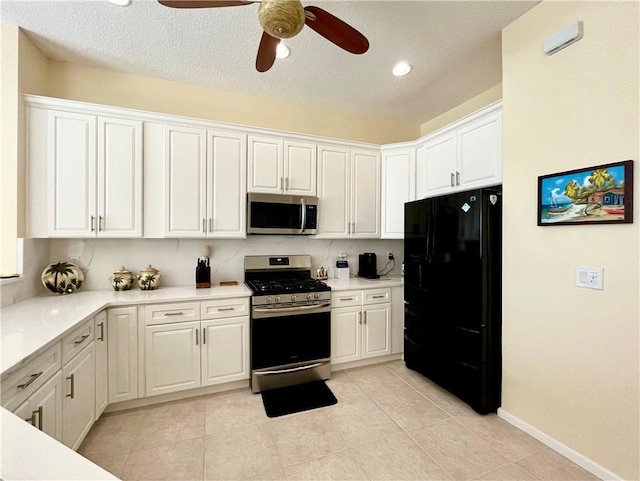 kitchen with white cabinets, light tile patterned floors, stainless steel appliances, and ceiling fan