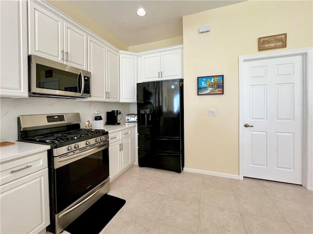 kitchen featuring white cabinetry, light tile patterned floors, a textured ceiling, and appliances with stainless steel finishes