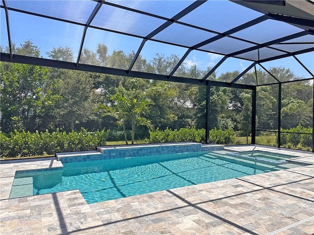 view of pool with a patio, an in ground hot tub, and glass enclosure