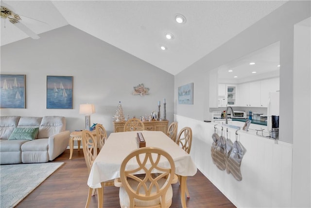 dining space featuring dark hardwood / wood-style floors, ceiling fan, and vaulted ceiling