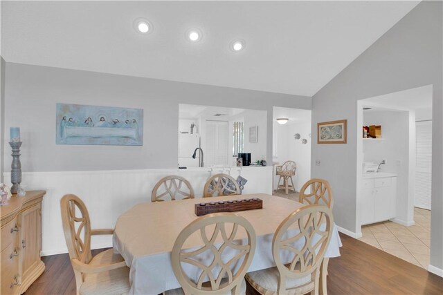 dining area with light wood-type flooring and lofted ceiling