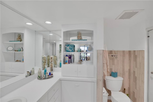 bathroom with vanity, toilet, and a shower