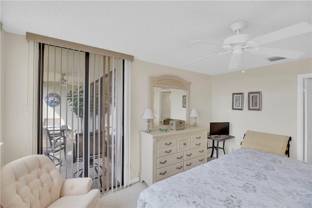 carpeted bedroom with access to outside, ceiling fan, and a textured ceiling