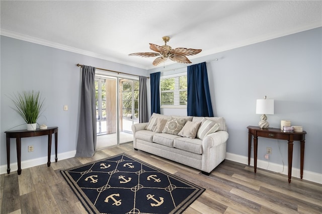 living room featuring baseboards, ornamental molding, ceiling fan, and wood finished floors