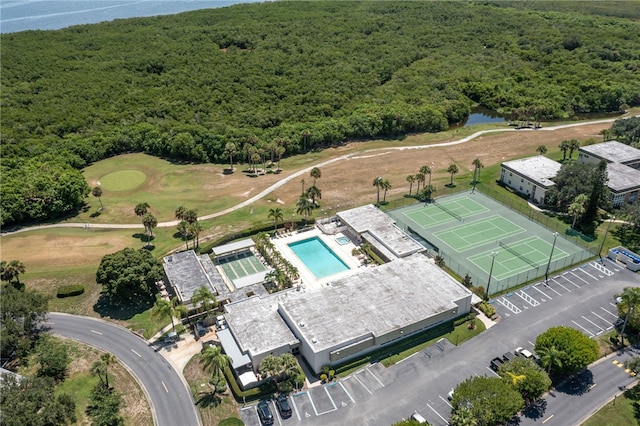 aerial view featuring golf course view, a water view, and a forest view