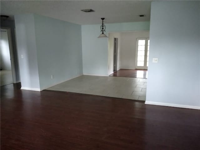 unfurnished room with dark wood-type flooring