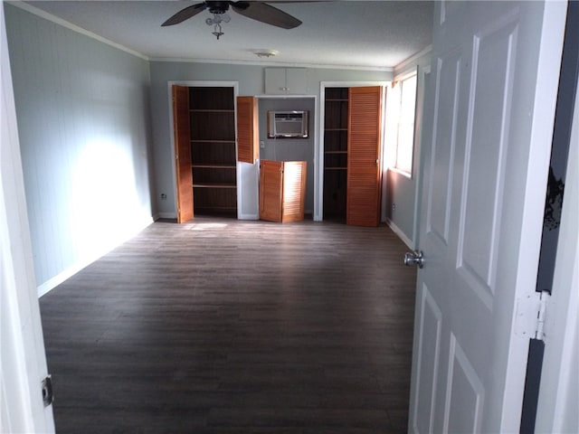 interior space with ceiling fan, dark hardwood / wood-style flooring, crown molding, and a wall mounted AC