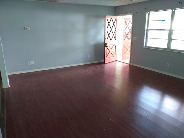 spare room with dark hardwood / wood-style flooring and ceiling fan