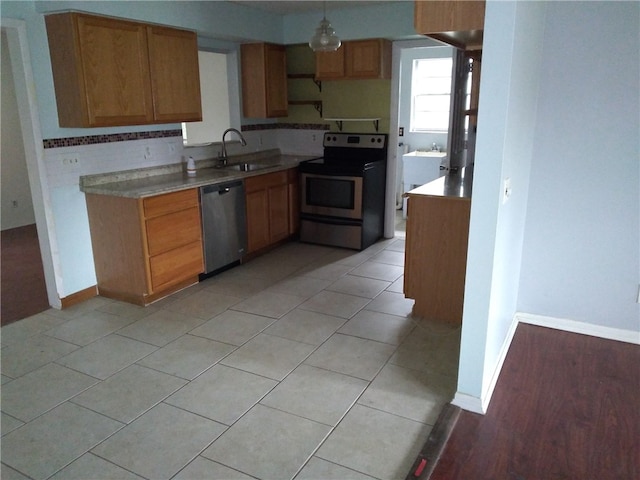 kitchen with light tile patterned flooring, sink, and stainless steel appliances