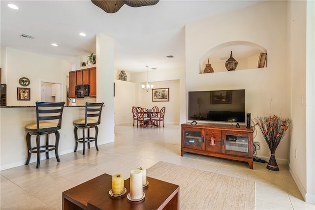 living room featuring ceiling fan with notable chandelier and light tile patterned flooring