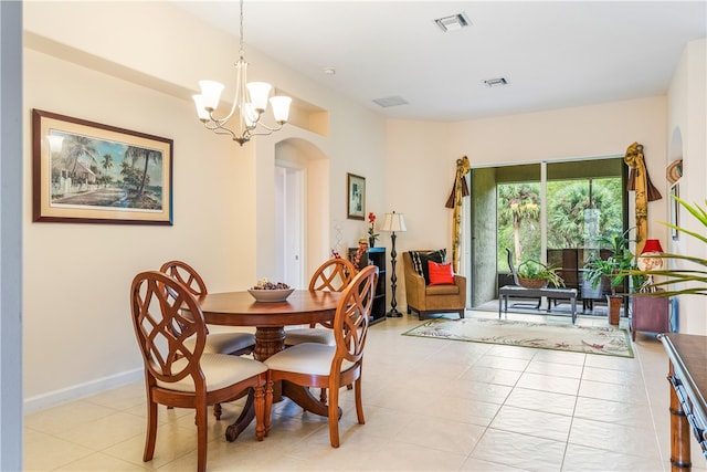 dining area with light tile patterned floors and an inviting chandelier