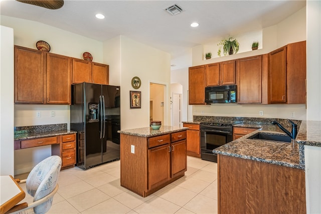 kitchen with black appliances, dark stone countertops, light tile patterned floors, and sink