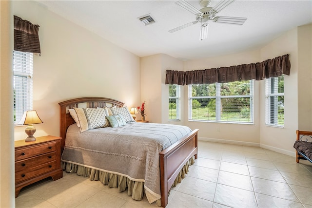 tiled bedroom with multiple windows and ceiling fan