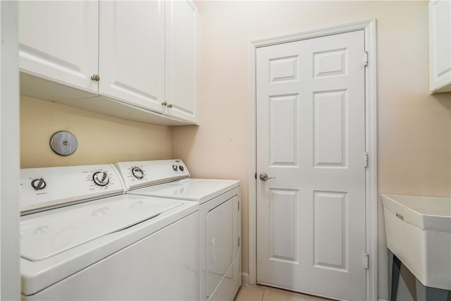 washroom featuring cabinets, light tile patterned floors, separate washer and dryer, and sink