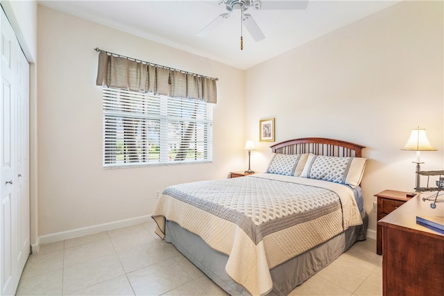 bedroom featuring ceiling fan, light tile patterned flooring, and a closet