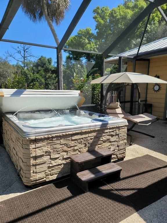 view of patio featuring a lanai and a hot tub