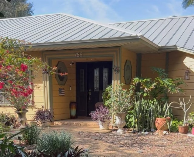 entrance to property featuring a standing seam roof and metal roof