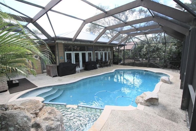 outdoor pool featuring french doors, a patio area, and a lanai