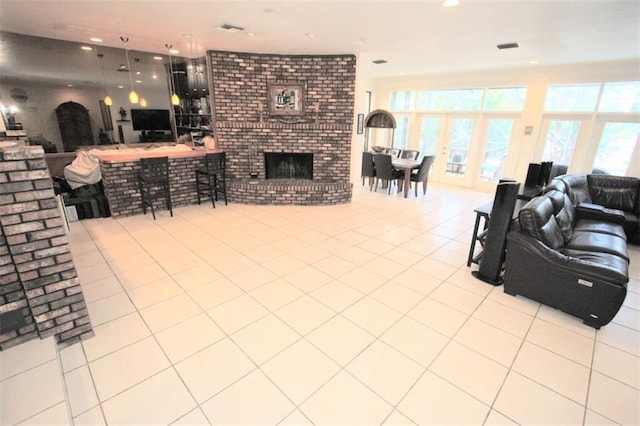 tiled living room featuring recessed lighting, a fireplace, and french doors