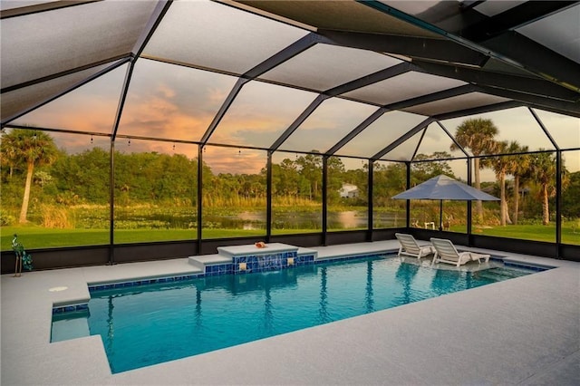 pool at dusk with a lanai, a patio area, and pool water feature