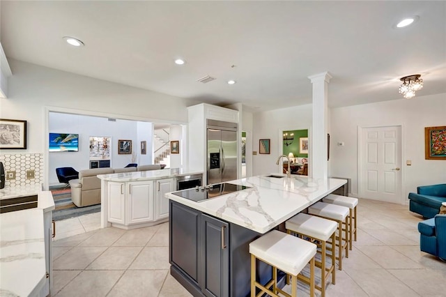 kitchen with stainless steel built in fridge, white cabinetry, open floor plan, and black electric cooktop