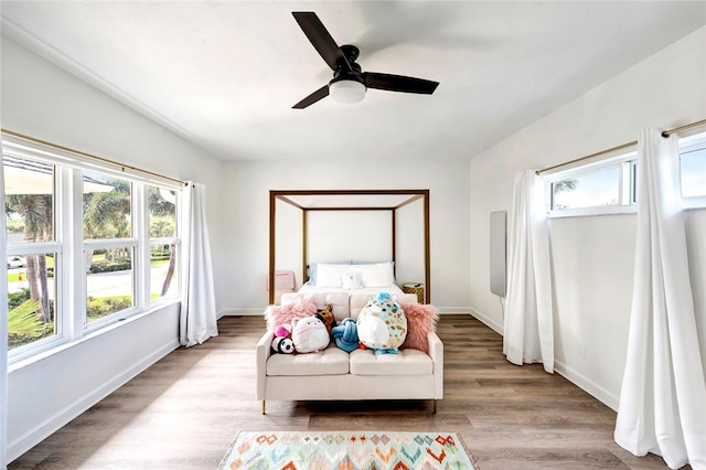 bedroom with baseboards, wood finished floors, and a ceiling fan