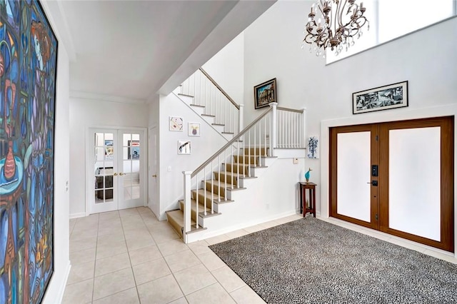 tiled entrance foyer featuring french doors, a chandelier, and stairway